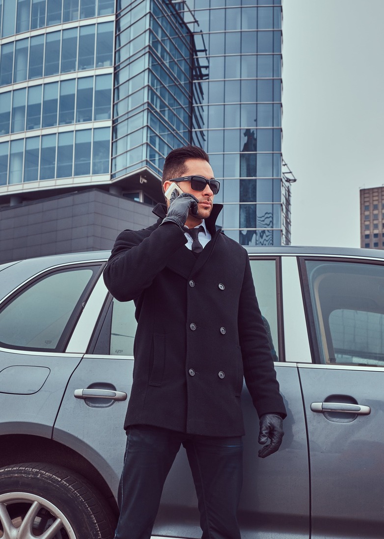 Bodyguard mit Sonnenbrille am Auto